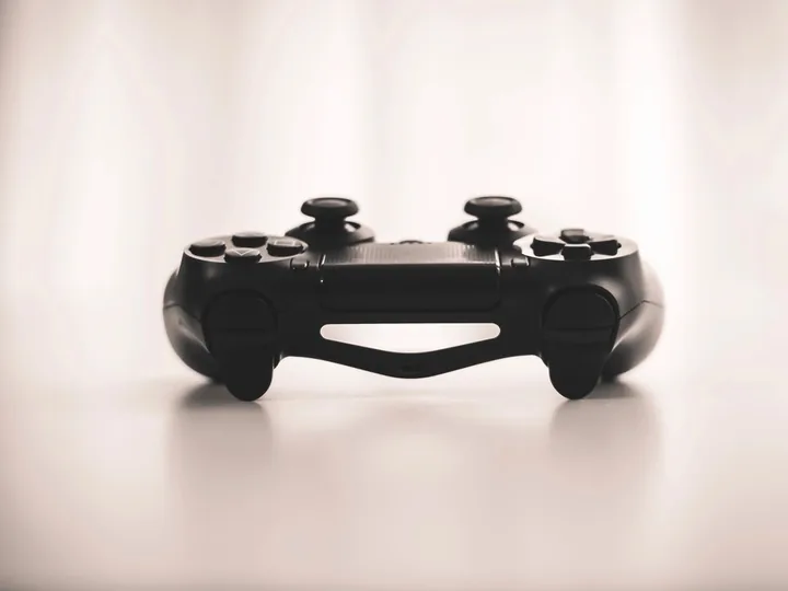 Black game controller on a white surface