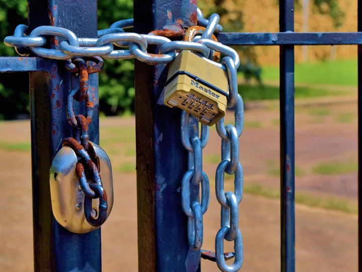 Padlock and chain on a metal gate