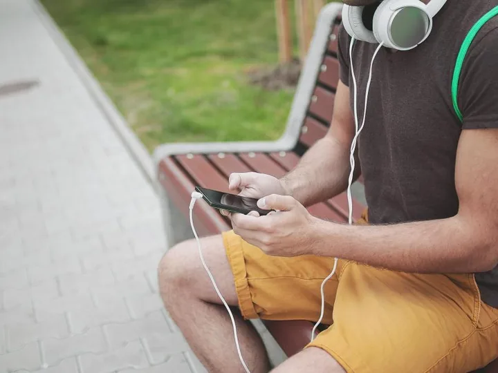 Person playing a mobile game on a phone with headphones