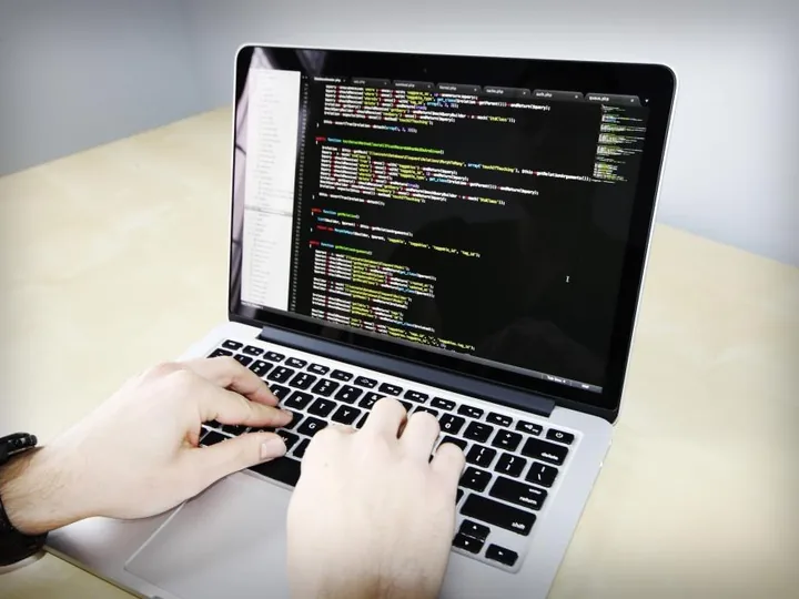 Laptop screen showing code next to a phone