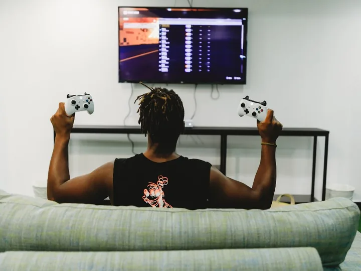 Person on a couch playing games on a TV