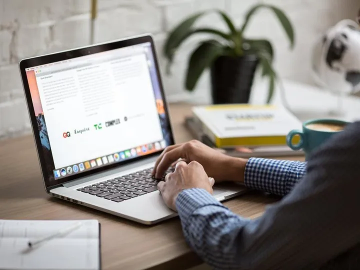 Laptop on a desk with a coffee cup