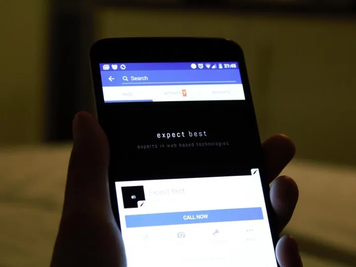 Hand holding a phone with a web page open